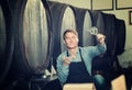 Winemaker holding glass of wine in cellar