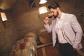 Winemaker inspecting wine in basement