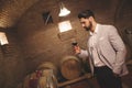 Winemaker inspecting wine in basement