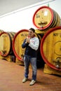 Winemaker standing next to wooden barrels at a winery in Montalc