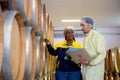 Winemaker team checking and examining producing wine at winery in factory.