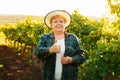 winemaker woman with hat showing thumb up and looking at camera