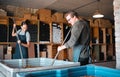 Winemaker workers in the process of making wine with a wine press tool or equipment in a warehouse, winery or distillery