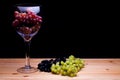 Winemaking. Glass of red wine grapes. White and black grape varieties. Royalty Free Stock Photo