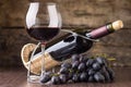 Winery background. Wineglass with bottle of red wine and cluster of grape Royalty Free Stock Photo