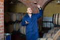 Winery employee in cellar with glass of wine Royalty Free Stock Photo