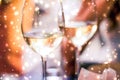 Winter holiday glasses of white wine and glowing snow on background, Christmas time romance Royalty Free Stock Photo