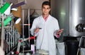 Winery technician controlling fermantation process of wine