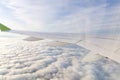 The wing of an airborne aircraft above the clouds. sunny weather and thick clouds