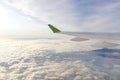 The wing of an airborne aircraft above the clouds. sunny weather and thick clouds