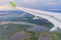 The wing of an airborne aircraft over land and water. sunny weather. beautiful view