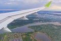 The wing of an airborne aircraft over land and water. sunny weather. beautiful view