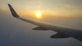 Wing of the aircraft looking from the airplane window and catching first sunset Royalty Free Stock Photo