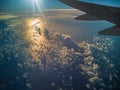 Wing of the aircraft over the Atlantic Ocean waters in the sun rays Royalty Free Stock Photo