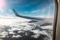 Wing of an airplane above the clouds, background of a blue sky. The photo was taken from the window of the plane. Royalty Free Stock Photo