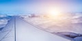 Wing of airplane above the clouds at sunrise. Royalty Free Stock Photo