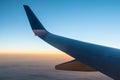 Wing of airplane above clouds at sunset Royalty Free Stock Photo