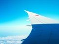 Wing of airplane above many white clouds from window blue sky japan Royalty Free Stock Photo