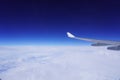 The wing of an airplane above solid clouds. Royalty Free Stock Photo