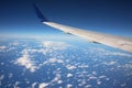 Wing of airplane above white clouds Royalty Free Stock Photo
