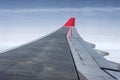 Wing of airplane from Air in the sky winglet red colored airline blue sky clouds Royalty Free Stock Photo