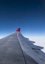 Wing of airplane from Air in the sky winglet red colored airline blue sky clouds Royalty Free Stock Photo