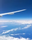 Wing of an airplane on blue sky with clouds Royalty Free Stock Photo