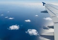 Wing of an airplane in flight over a vast expanse of ocean. The wing, with its sleek, metallic Royalty Free Stock Photo