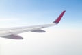 Wing of an airplane flying above the blue sky and clouds Royalty Free Stock Photo