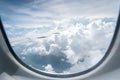 Wing of airplane flying above the clouds in the blue sky background through the window. Royalty Free Stock Photo