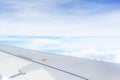 Wing of airplane flying above clouds blue sky background Royalty Free Stock Photo