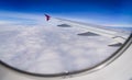 Wing of airplane flying above the clouds in the blue sky Royalty Free Stock Photo