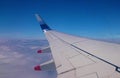 Wing of airplane flying above clouds, blue sky Royalty Free Stock Photo