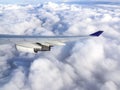 Wing of airplane flying above the clouds in the sky Royalty Free Stock Photo