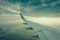 Wing of an airplane flying above the clouds at sunset . ( Filter Royalty Free Stock Photo