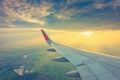 Wing of an airplane flying above the clouds at sunset . ( Filter Royalty Free Stock Photo