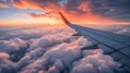 Wing of an airplane flying above the clouds at sunset. View from the window of an airplane. Royalty Free Stock Photo