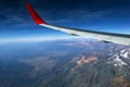 Wing of an airplane flying above the morning clouds and Andean mountain range Royalty Free Stock Photo