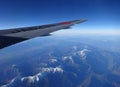 Wing of an airplane flying above the mountains Royalty Free Stock Photo