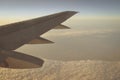 Wing of an airplane flying above the sunset clouds Royalty Free Stock Photo