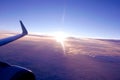 Wing of an airplane flying above sunset clouds Royalty Free Stock Photo