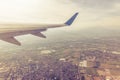 Wing of an airplane flying above towns and villages