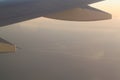 Wing of an airplane flying over the morning clouds in the sky Royalty Free Stock Photo