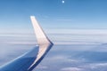 Wing of an airplane over clouds in front of Moon Royalty Free Stock Photo