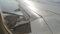 Wing of an airplane, passenger s view. Looking through the window of a plane on its shining wing Royalty Free Stock Photo