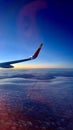 Wing of Airplane Soaring Above Clouds in Clear Blue Sky Royalty Free Stock Photo