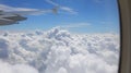 wing of airplane and the white clouds from above seen from the window porthole Royalty Free Stock Photo