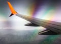 Wing of a civilian airliner airplane in flight with mountains with optical effect Royalty Free Stock Photo