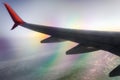 Airplane wing in flight above clouds with optical effect Royalty Free Stock Photo