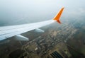 wing of a flying civil airliner over the city of Georgia